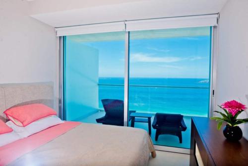 1 dormitorio con cama y vistas al océano en PENINISULA ViSTA AL MAR BY ENNA INN IXTAPA, en Ixtapa