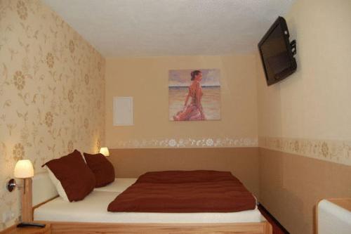 a bedroom with a bed and a tv on the wall at Anitas Ferienhaus in Cochem