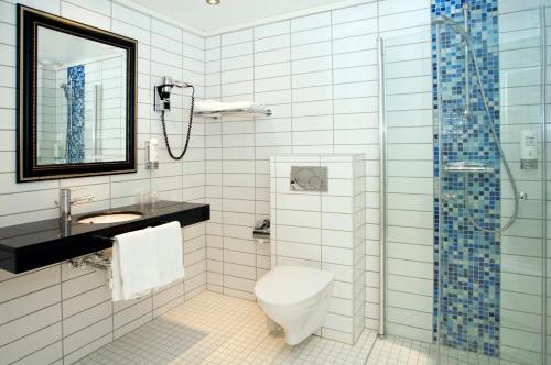 a bathroom with a toilet and a sink and a shower at Quality Hotel Prinsen in Trondheim