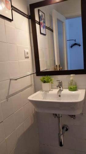 a white bathroom with a sink and a mirror at Nossa Casa na Aldeia in Viseu