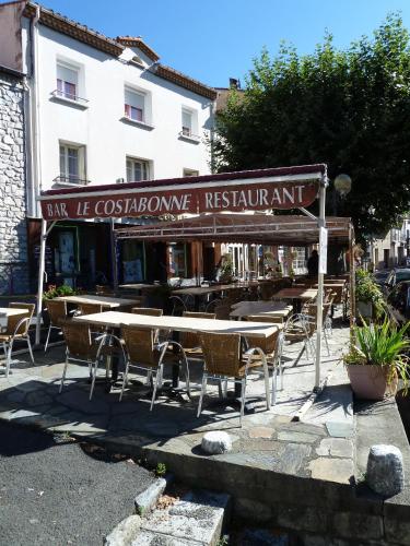 a restaurant with tables and chairs in front of a building at Maison Baxter in Prats-de-Mollo-la-Preste