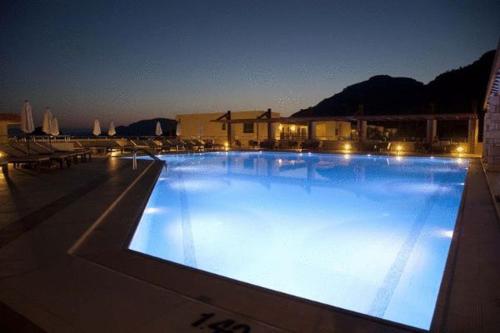 a large swimming pool lit up at night at Island Blue Hotel in Pefki