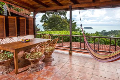 a porch with a hammock and a view of the ocean at Hotel Villas Nicolas - Adults Only in Manuel Antonio