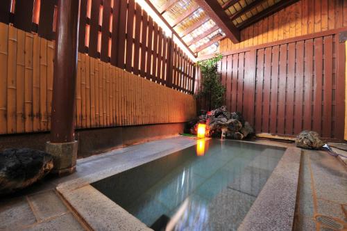 a swimming pool in a building with a ceiling at Daitokan in Kusatsu