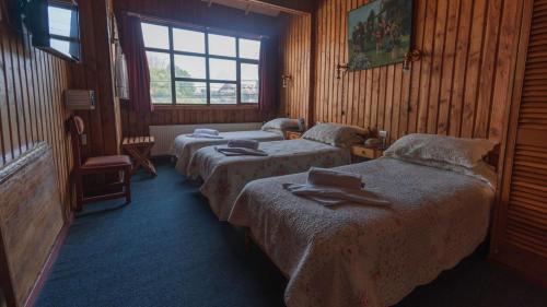 a hotel room with two beds and a window at Hotel Balai in Ancud