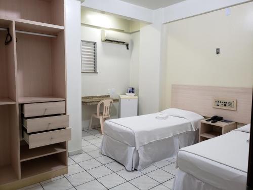 ein Krankenhauszimmer mit 2 Betten und einem Schreibtisch in der Unterkunft Hotel Danúbio in Belém