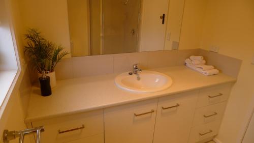 a bathroom with a sink and a mirror and towels at OCEAN BREEZE in Warrnambool