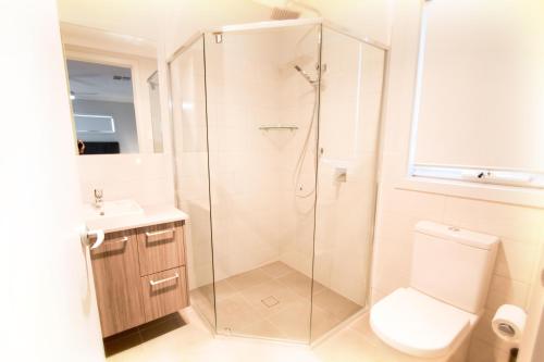 uma casa de banho com um chuveiro, um WC e um lavatório. em Wellington Lake Retreat em Wellington East