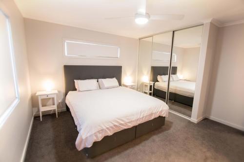 a bedroom with a large bed and a mirror at Wellington Lake Retreat in Wellington East
