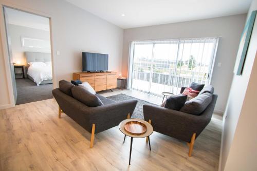 a living room with two couches and a television at Wellington Lake Retreat in Wellington East
