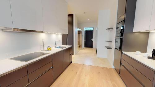 cocina grande con armarios blancos y suelo de madera en White Pearl Apartment 4.20, en Timmendorfer Strand