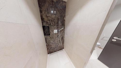 a bathroom with a shower with a stone wall at White Pearl Apartment 1.02 in Timmendorfer Strand