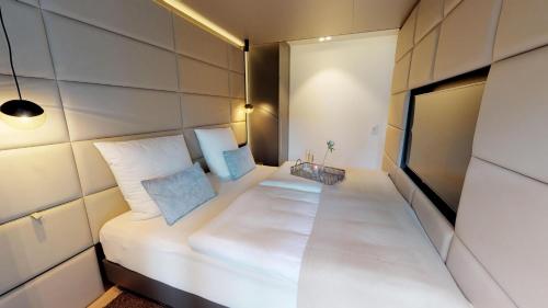 a small room with a white bed with two pillows at White Pearl Apartment 1.02 in Timmendorfer Strand
