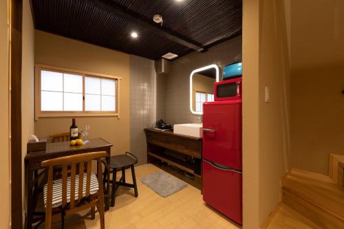 Elle comprend une petite cuisine équipée d'un réfrigérateur rouge et d'une table. dans l'établissement Shirakabanoyado - Uchikyuhoji, à Osaka