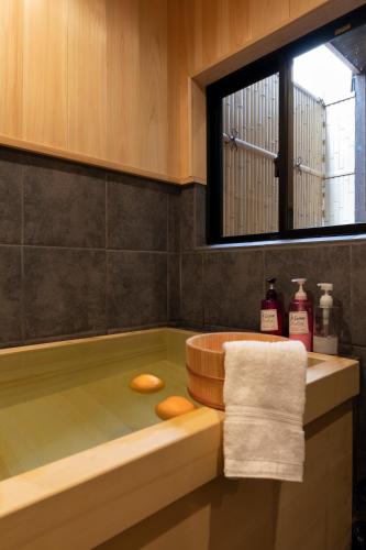 a bathroom with a bath tub with a window at Shirakabanoyado-DOUNIWA, Private House Near Osaka Castle, 白樺の宿-堂庭 in Osaka