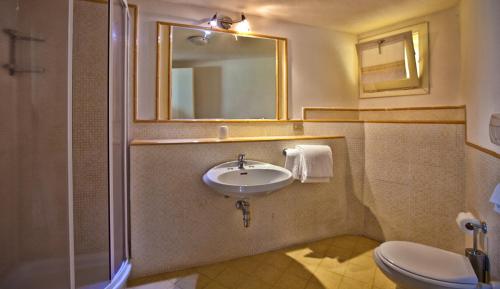 bagno con lavandino, specchio e servizi igienici di Residence Stella Di Gallura a Porto Rotondo