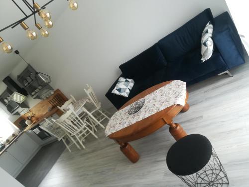 a living room with a blue couch and a chair at Apartament Roztocze in Zamość
