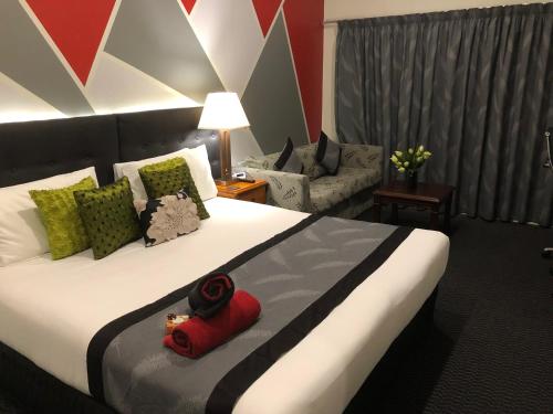 a hotel room with a large bed and a couch at Silver Fern Lodge in Taupo