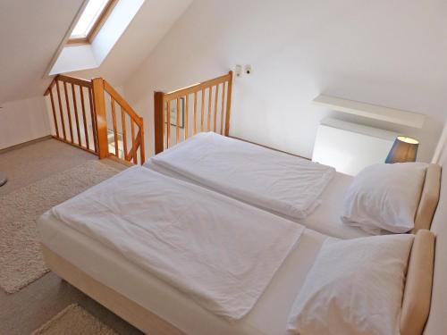 a bedroom with two beds with white sheets at Obere Wandelbahn 15 Whg. 8 in Wittdün