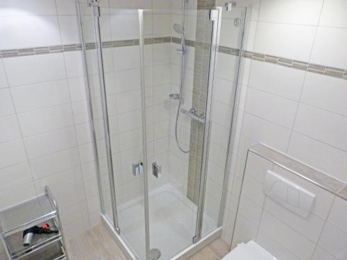 La salle de bains est pourvue d'une douche avec une porte en verre. dans l'établissement Obere Wandelbahn 15 Whg. 8, à Wittdün