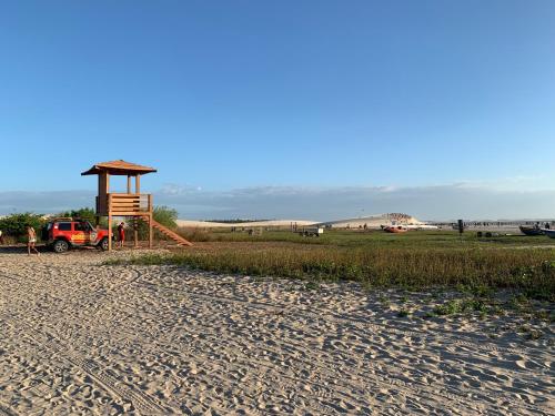 a lifeguard stand on a sandy beach with a truck at Villa Viana in Jericoacoara