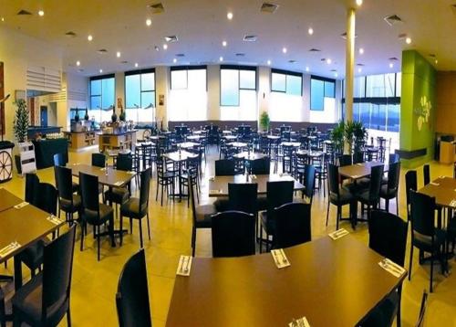 um restaurante com mesas e cadeiras num edifício em D Hotel em Seri Iskandar