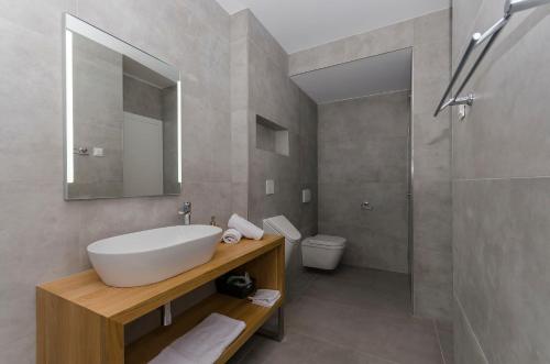 a bathroom with a sink and a shower and a toilet at Apartments Villa Adriana I in Srima