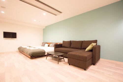 a living room with a couch and a bed at Hokkaido Asahikawa 7 - inn in Asahikawa