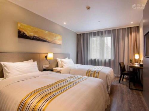 Habitación de hotel con 2 camas y escritorio en Home Inn Plus Lanzhou Zhangye Road Pedestrain Street en Lanzhou