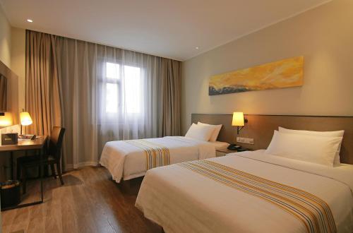 um quarto de hotel com duas camas e uma secretária em Home Inn Plus Lanzhou Zhangye Road Pedestrain Street em Lanzhou