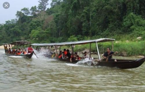 a group of people riding on a boat in the water at Naura Roomstay in Kuala Tahan