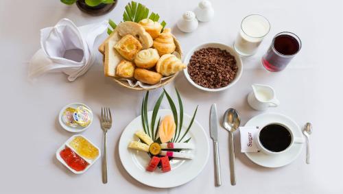 a table with plates of food and a cup of coffee at Hotel Somadevi Angkor Resort & Spa in Siem Reap