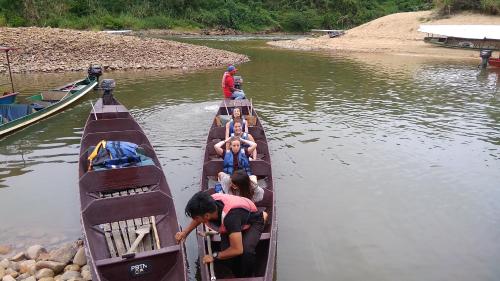 a group of people in two boats on a river at Naura Roomstay in Kuala Tahan