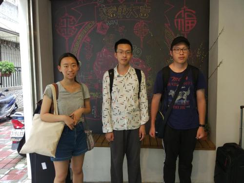 a group of three people standing in front of a wall at mydeer backpacker in Tainan