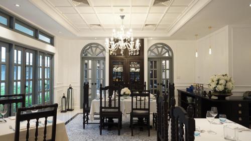 a dining room with a table and chairs and a chandelier at Souphattra Hotel Luang Prabang in Luang Prabang