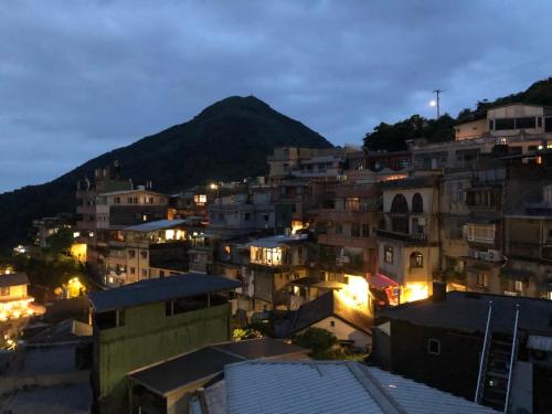 a city at night with a mountain in the background at 九窩Jiu Wow Box Inn Jiufen九份 in Jiufen