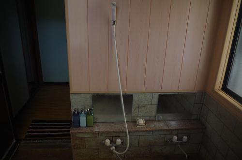 a shower in the corner of a room at Kusatsu Onsen Guesthouse Gyoten in Kusatsu