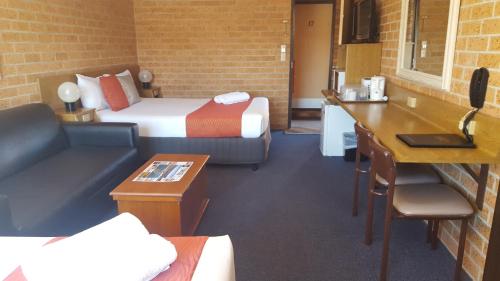 a hotel room with a bed and a couch at Royal Palms Motor Inn in Coffs Harbour