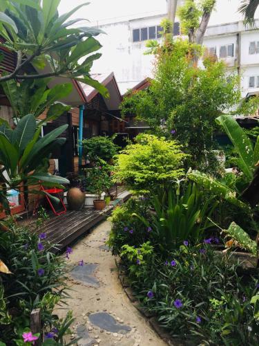 a garden with plants and flowers in front of a building at Noom Guesthouse in Lop Buri