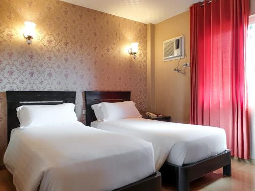two beds sitting next to each other in a room at Hanan Hotel Tagaytay - Formerly Tagaytay Wingate Manor in Tagaytay