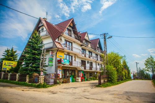 un gran edificio con techo de gambrel en una calle en DW Harnaś, en Bustryk