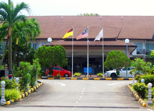 a hotel with flags in front of a building at Hotel Seri Malaysia Port Dickson in Port Dickson