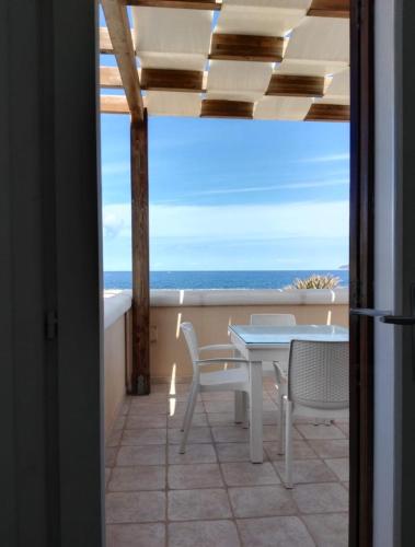 a table and chairs on a balcony with the ocean at Villa Oblò in Favignana