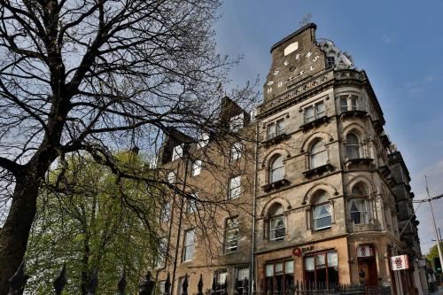 um edifício alto com uma árvore em frente em Best Western Queens Hotel em Dundee