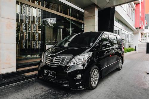 a black car parked in front of a building at The Alts Hotel in Palembang