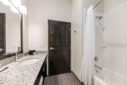 a bathroom with a sink and a brown door at Sleep Inn Baxley in Baxley