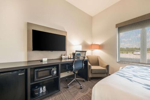a hotel room with a desk with a television and a bed at Sleep Inn Baxley in Baxley