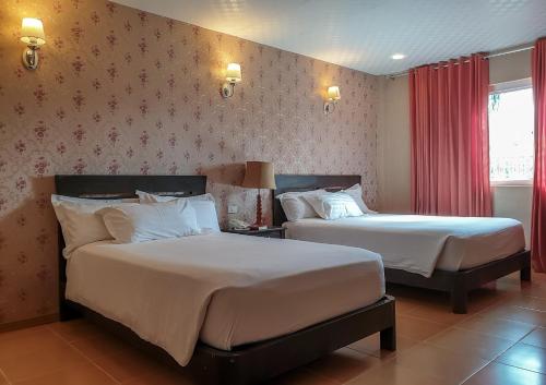 a hotel room with two beds in a room at Hanan Hotel Tagaytay - Formerly Tagaytay Wingate Manor in Tagaytay
