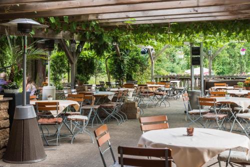an outdoor patio with tables and chairs and vines at Schützenhaus Bondorf in Bondorf