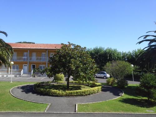a tree in a circle in front of a building at Apartamentos San Pedro en Llanes in Llanes